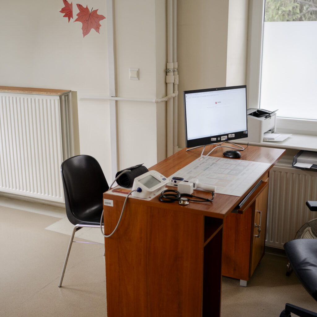 Biurko lekarskie z komputerem i aparatem do pomiaru ciśnienia w gabinecie medycznym