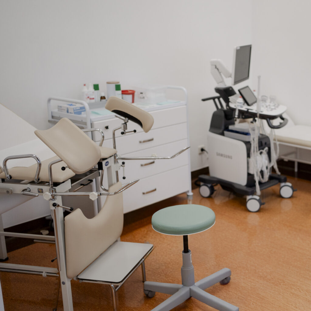 Gabinet ginekologiczny z fotelem zabiegowym, aparatem USG i sprzętem medycznym