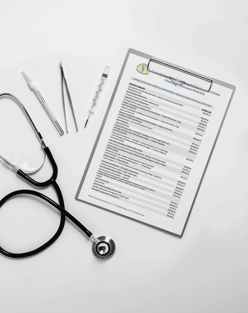 Stetoskop, termometr i cennik medyczny na biurku, symbolizujące pracę w służbie zdrowia.