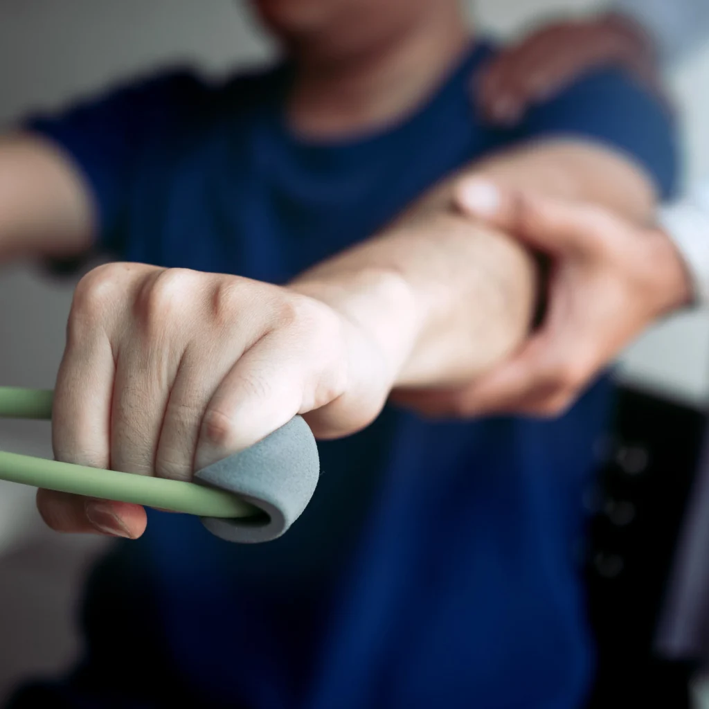 Fizjoterapeuta wspierający pacjenta podczas ćwiczeń z gumą oporową