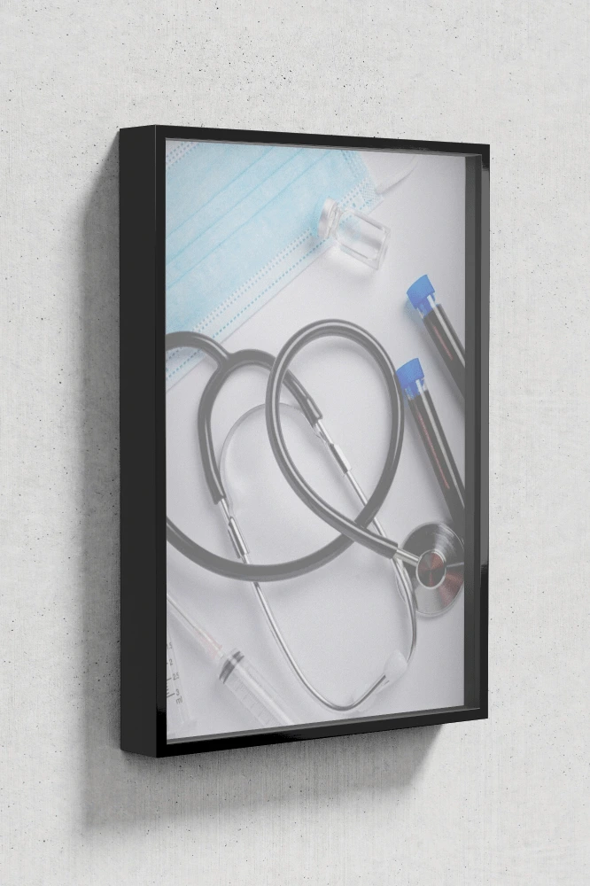 Plakat w czarnej ramie z grafiką stetoskopu ułożonego w kształt serca, strzykawek i probówek